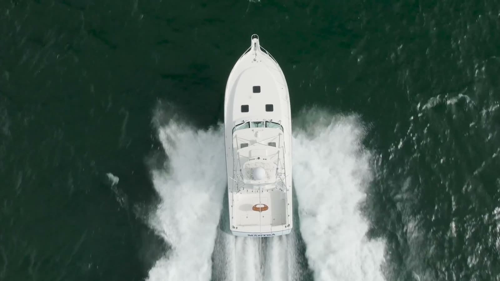 Aerial view of a center console under way — the drone photography included in every listing